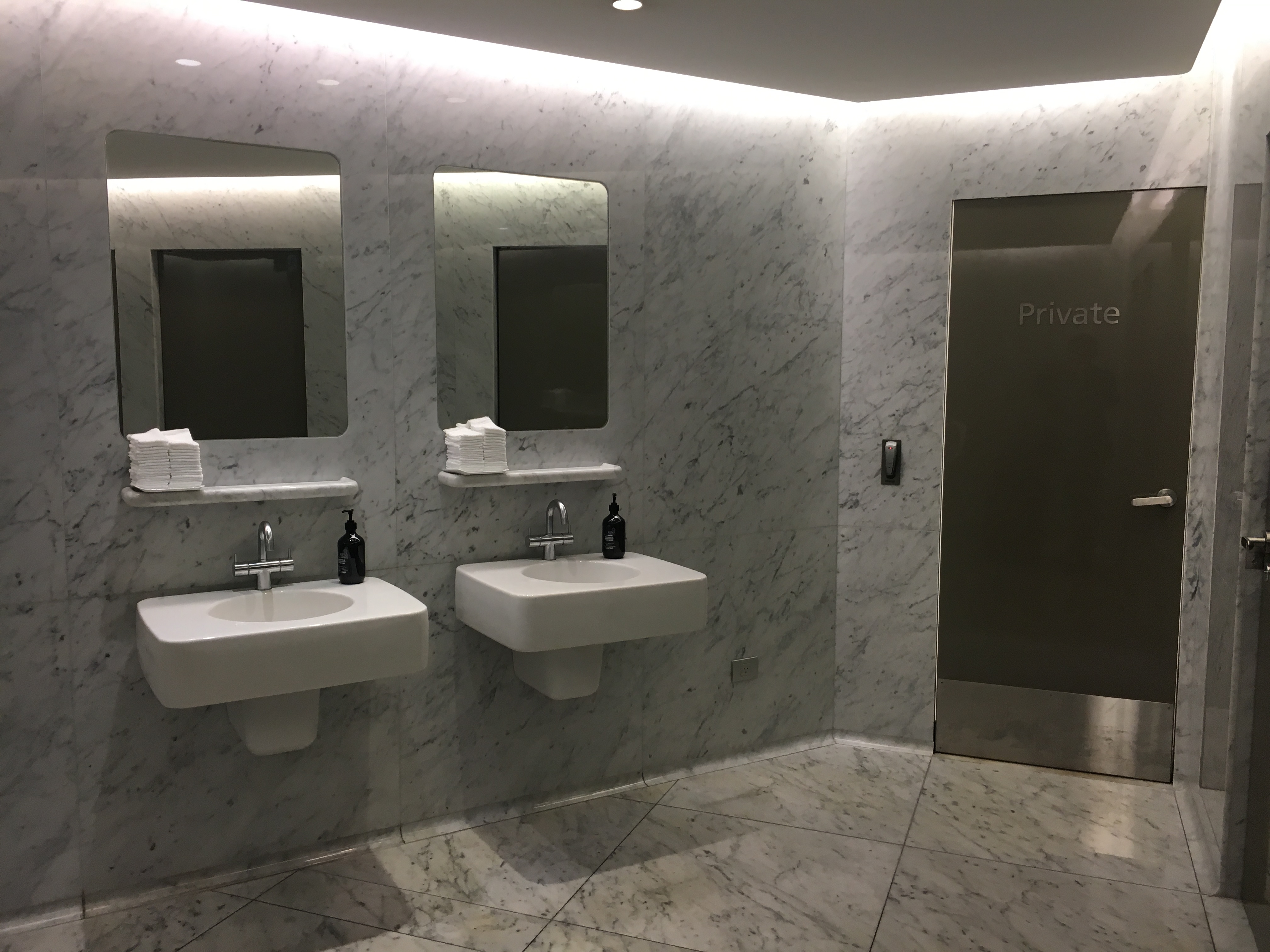 a bathroom with marble walls and mirrors