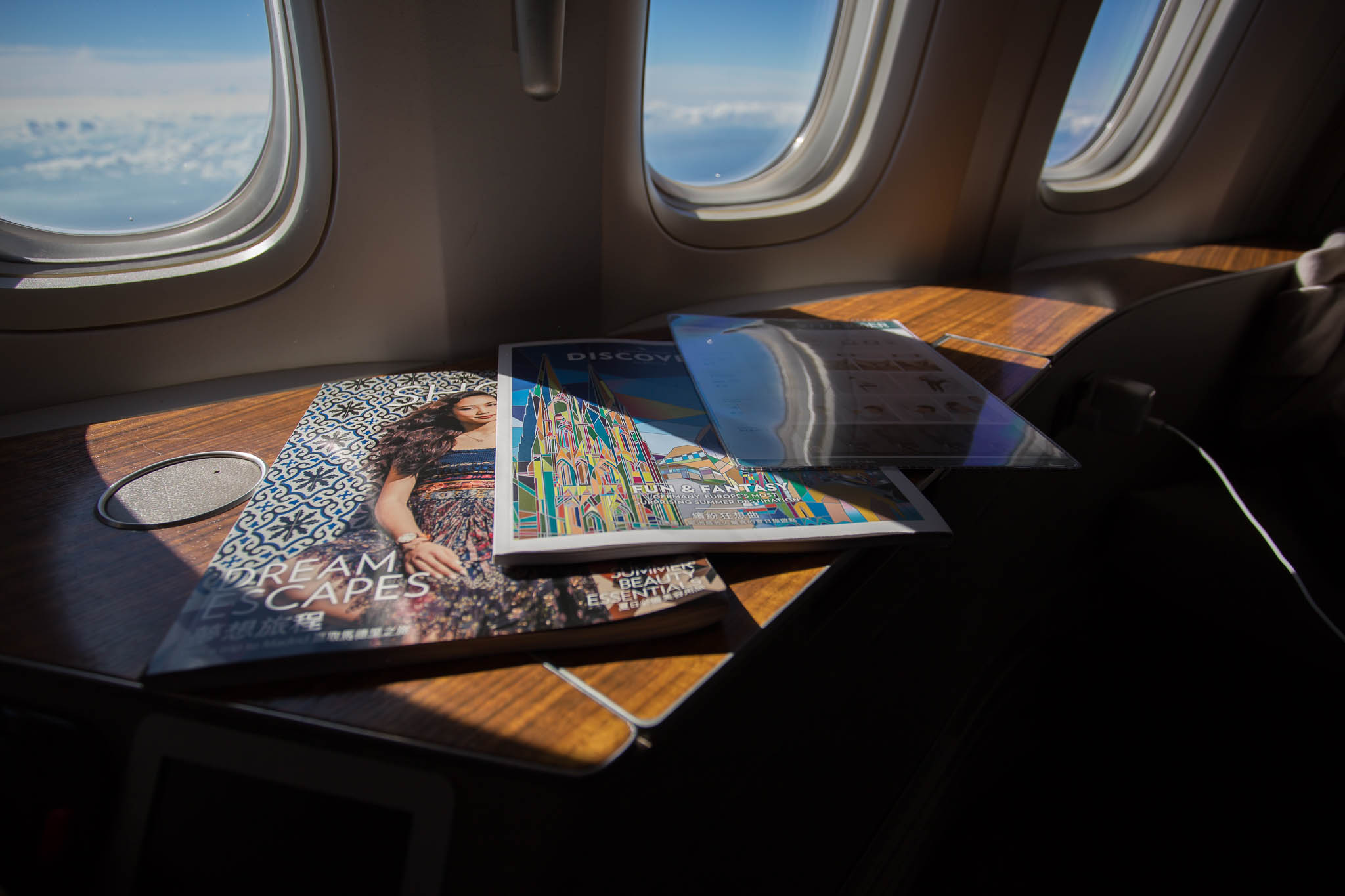 a magazine and magazines on a table with windows in the background